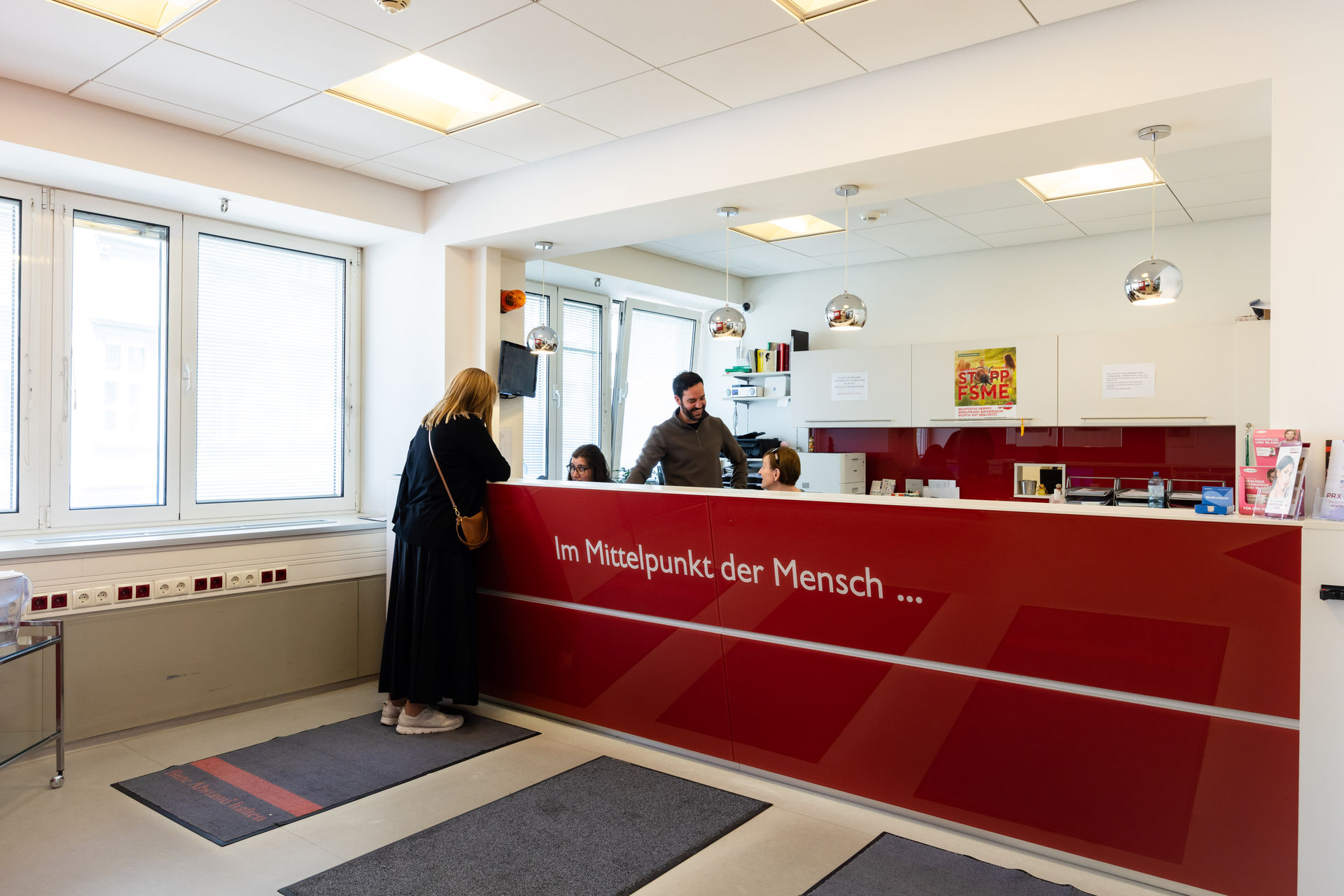 Patientin am Empfangstresen der Ordination